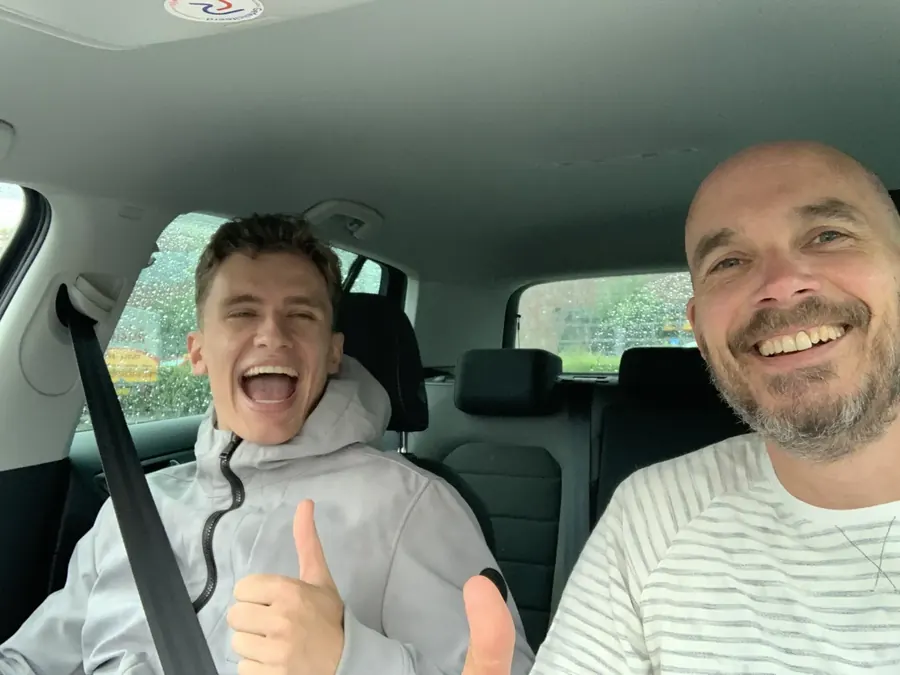 Reynoud met een blije leerling in de lesauto