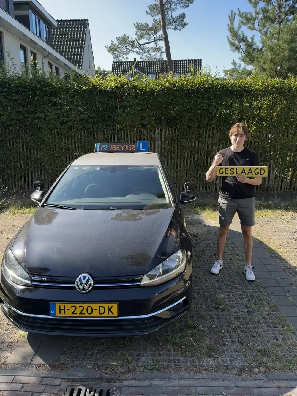 Geslaagd! Leerling van ReykR naast de lesauto