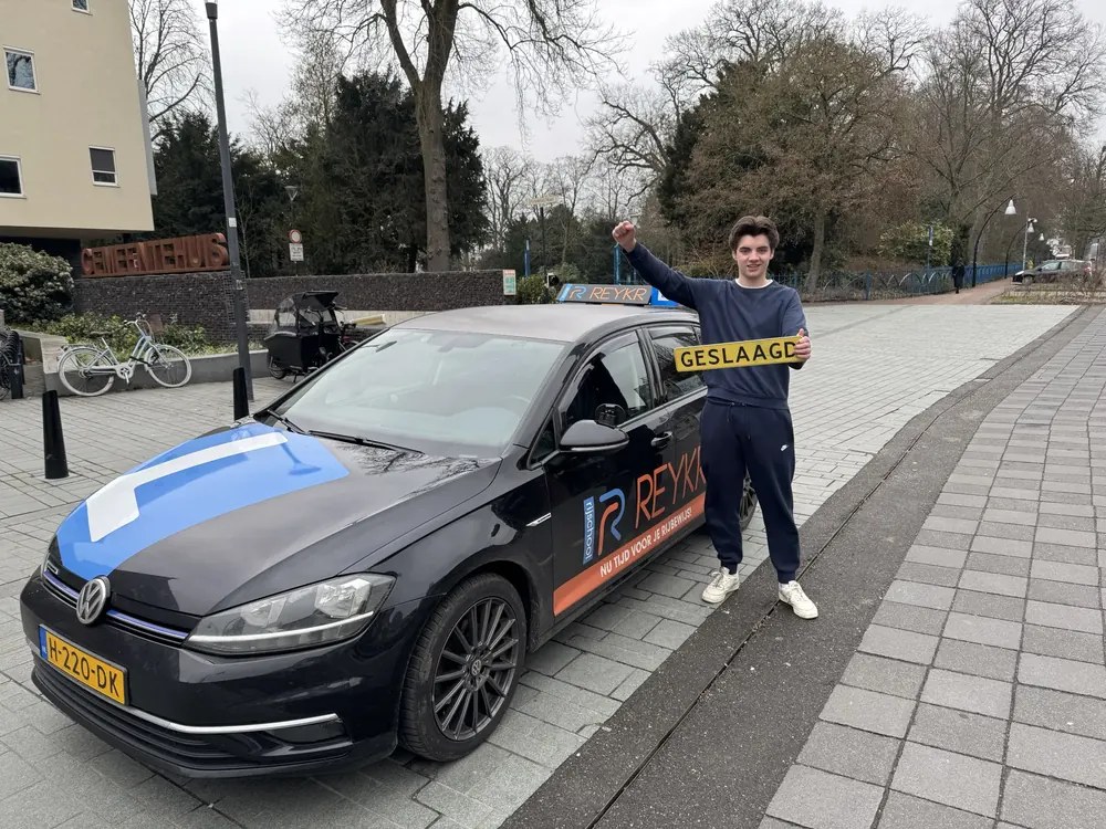 Geslaagde leerling bij de lesauto van ReykR